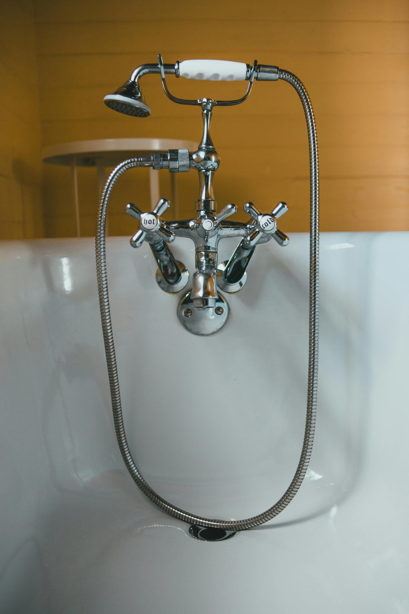 the headlight of a bathroom faucet is shown above a white bath tub