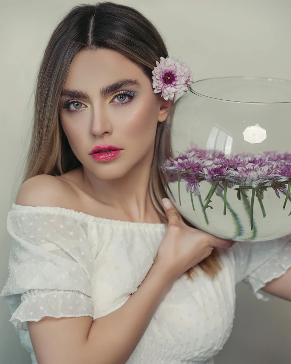 a woman holds a bowl filled with water and flowers