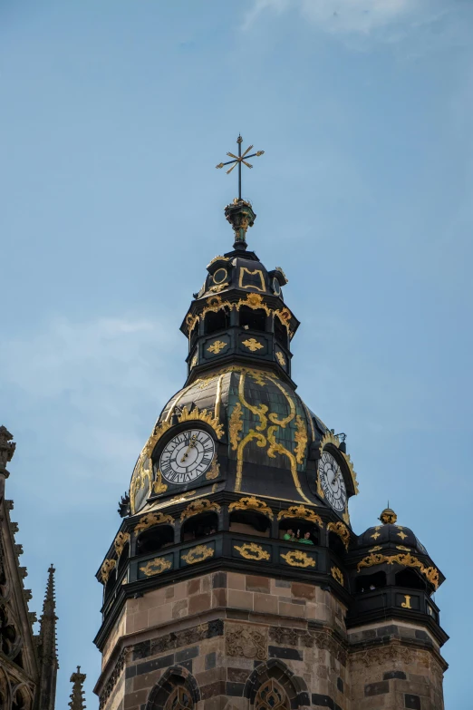 a clock tower with two clock faces and a cross at the top