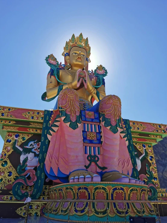 a large statue of a buddha on top of a building