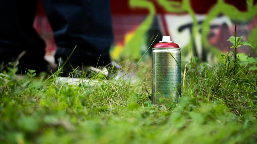 an aluminum travel bottle with a straw in the middle on some grass