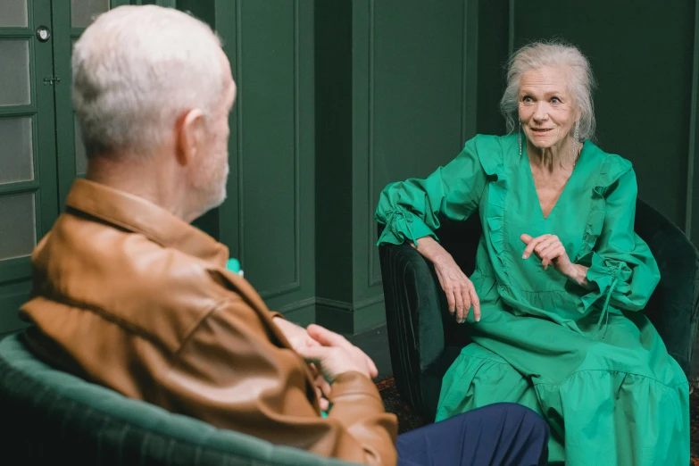 an older woman sitting in a chair near an older man