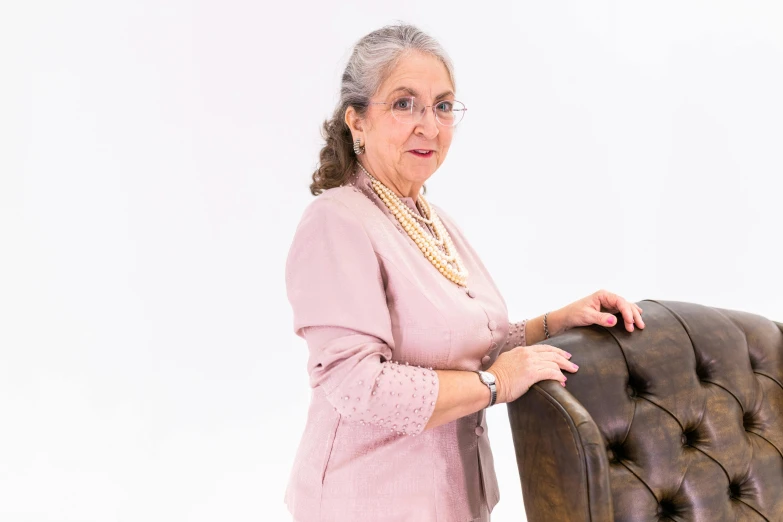 a women who is leaning on the arm of a chair