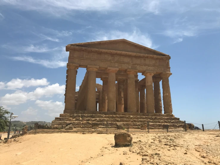 a stone monument on a sandy terrain against a blue sky