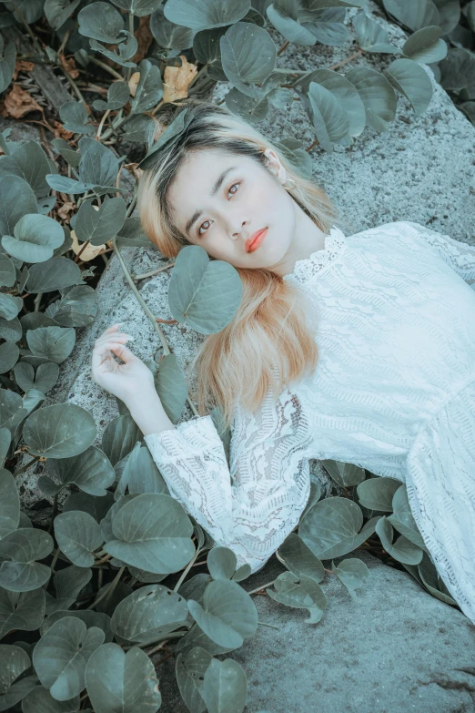 a pretty young lady laying down among leaves