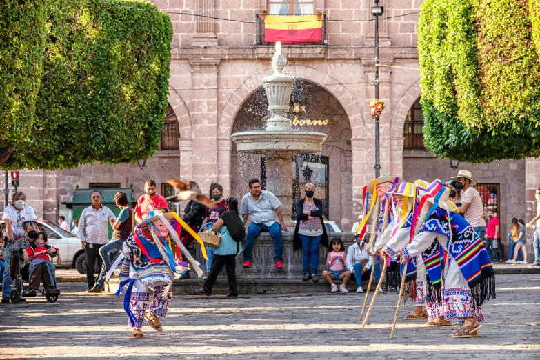 people standing on the street with many flags and decorations