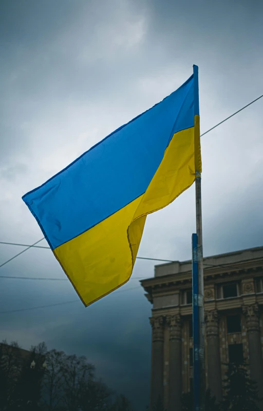 an ukraine flag waving on a dark day