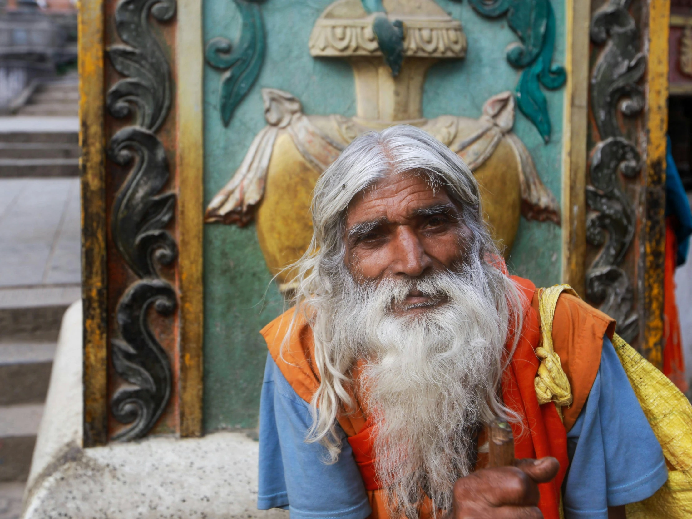 an old man with grey hair and beard wearing orange