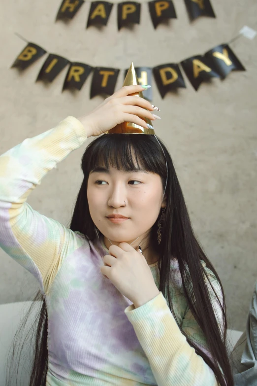 woman with birthday hat holding bottle on her head