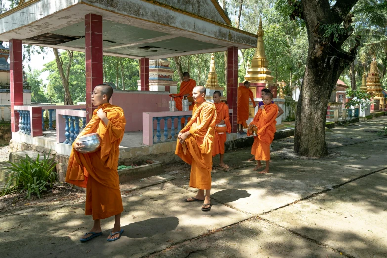 a group of people wearing orange robes in front of a building