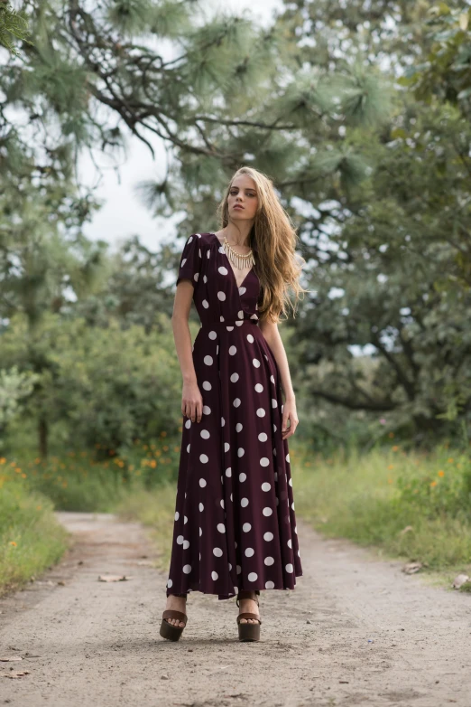 a woman in a purple and white polka dot dress