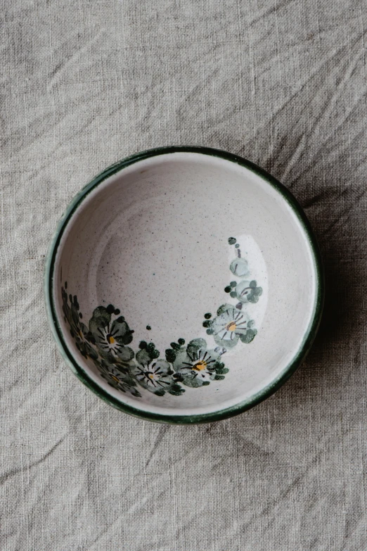 a green and white flower bowl on a grey surface