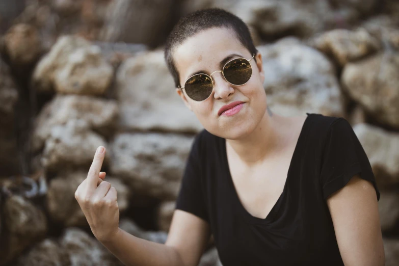 a woman with dark sunglasses pointing to the side