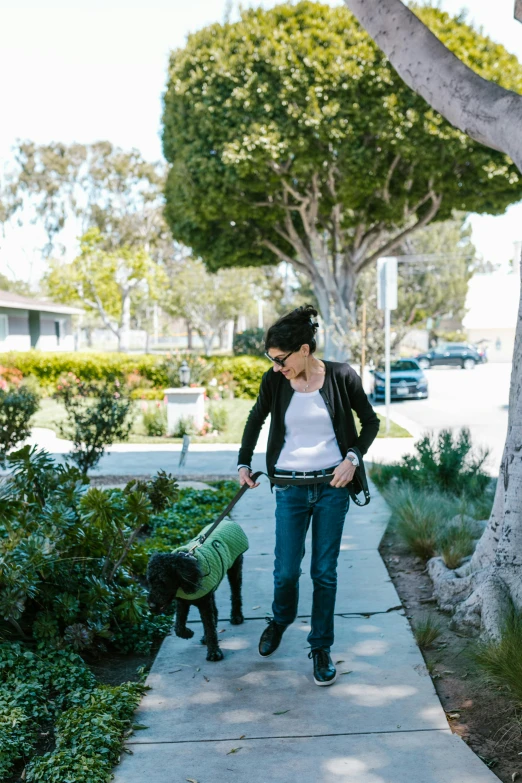 a woman is walking with a small dog