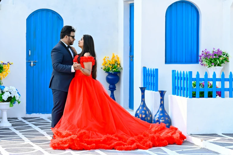 a man in a suit and a women in a red gown pose