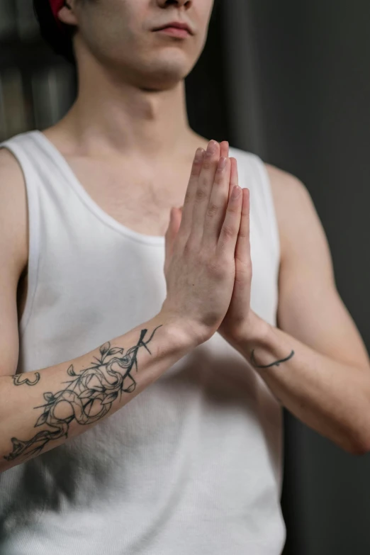 a young man holding his hands together while wearing a blindfold