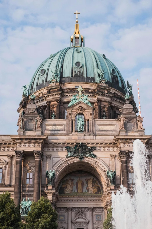 a large building with a dome with a fountain in front of it