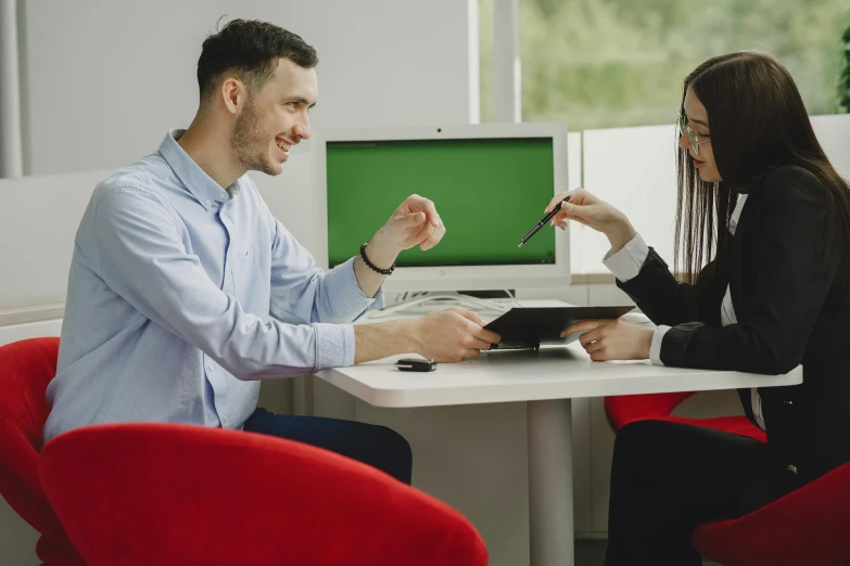 two people sitting at a table with a tablet in hand