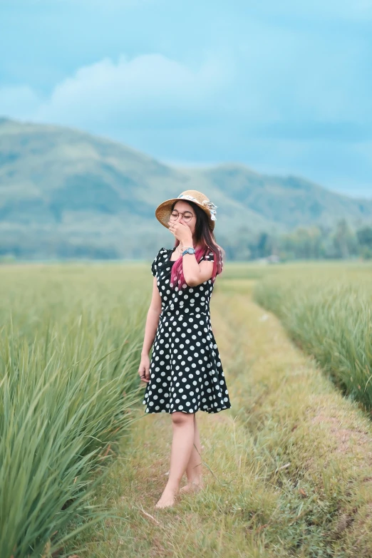 woman standing in the middle of a wheat field