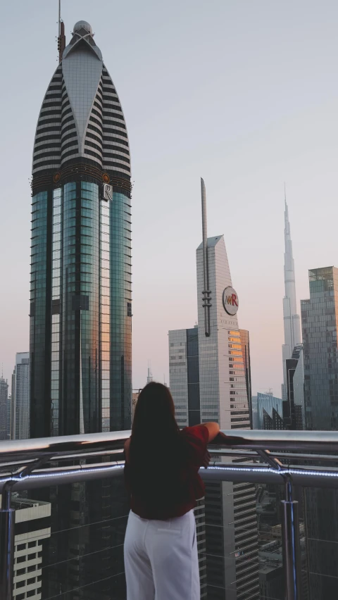 woman looking at skyscrs through her window