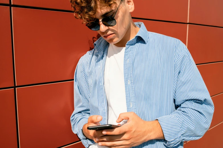 a young man checks his cell phone and checks it out