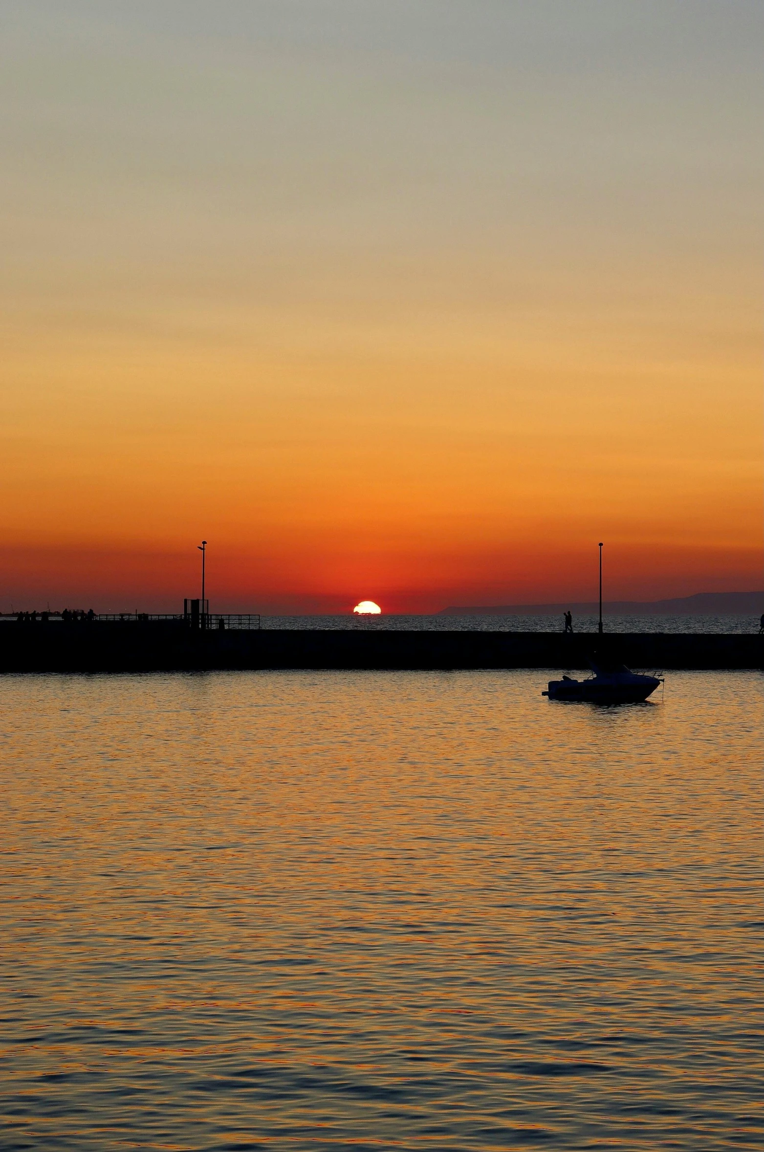 two boats sailing in the ocean at sunset