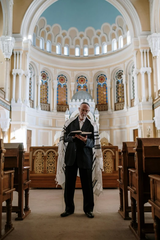 a man sitting in a church reading a book