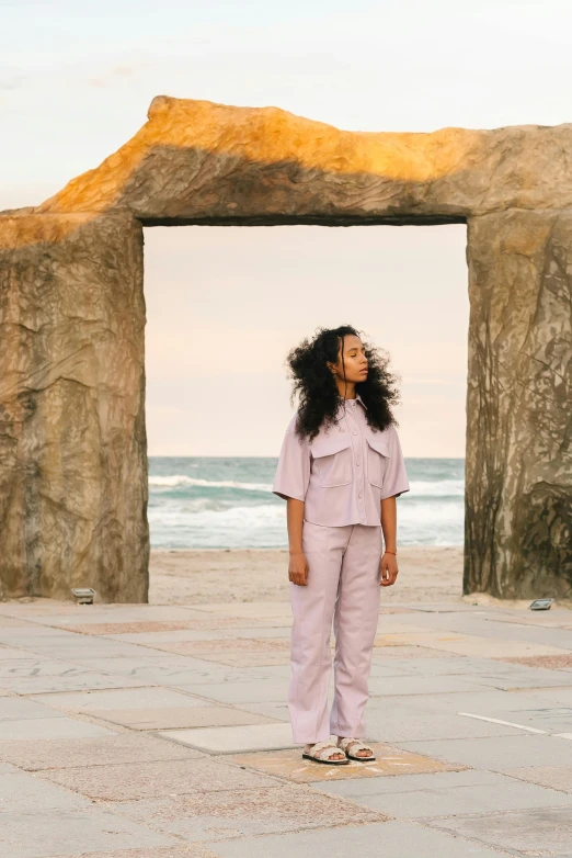 a woman standing under an arch in a desert