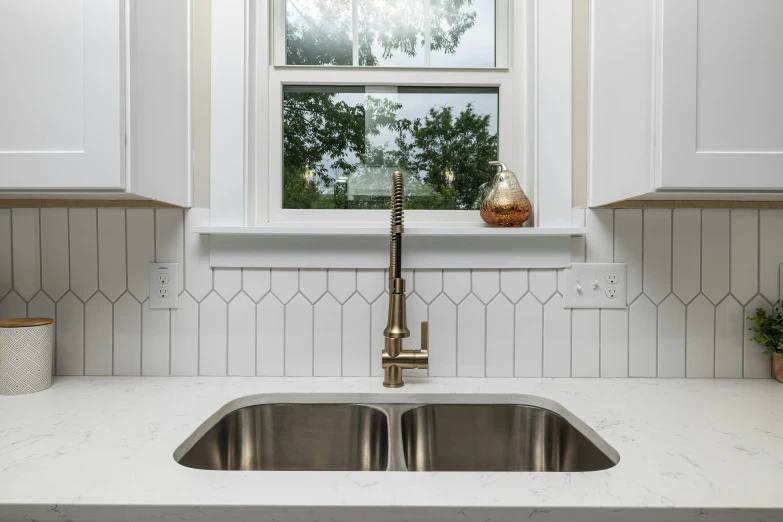 kitchen sink with white countertop and metal faucet