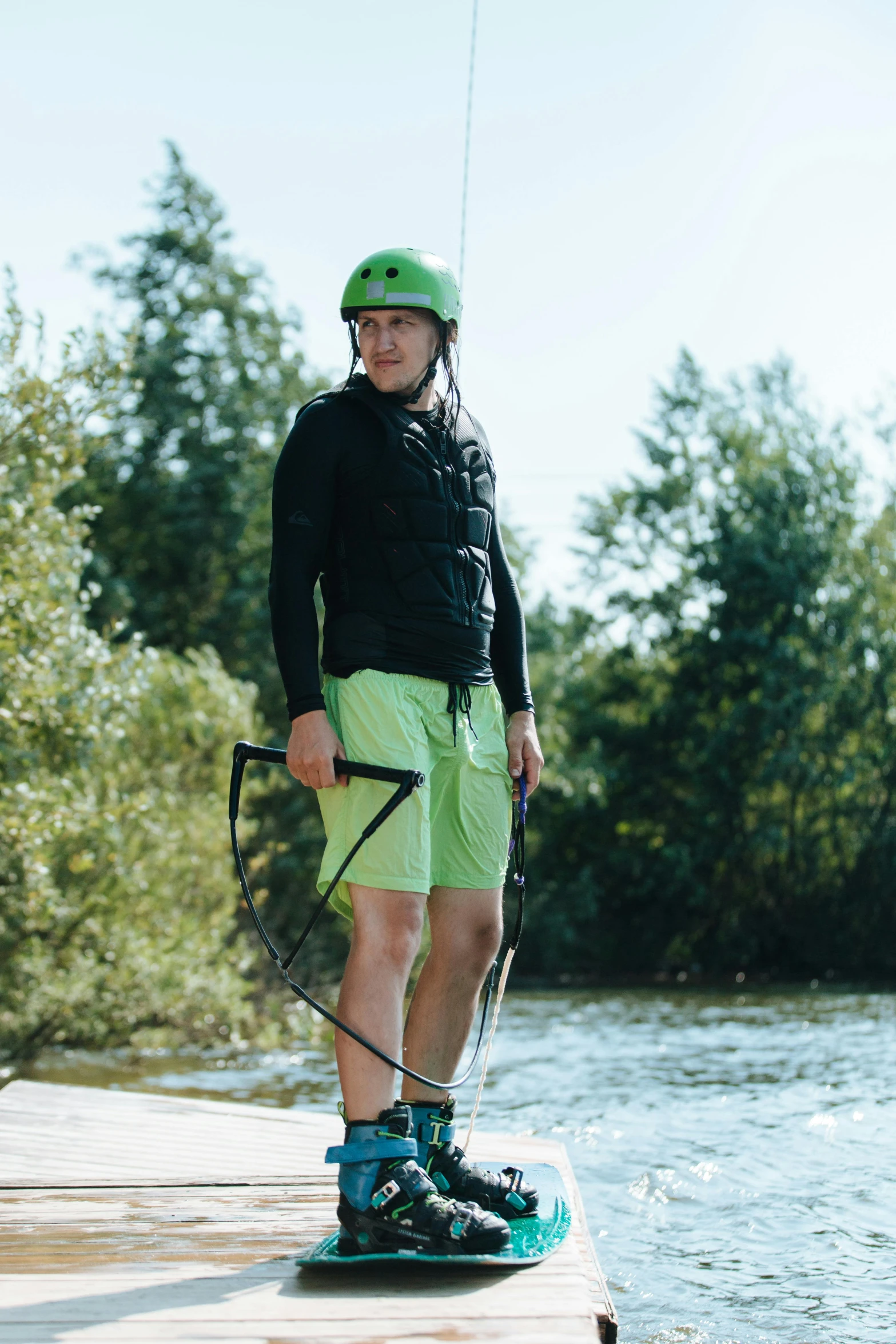 a young man standing on a small boat on top of water