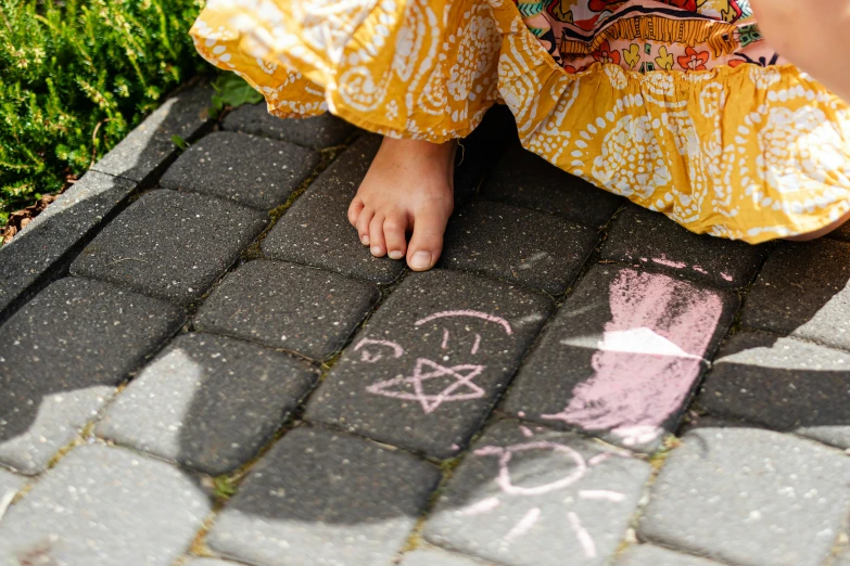 a woman standing on the ground painting with chalk