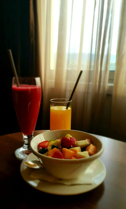 a bowl of fruit and juice on a table