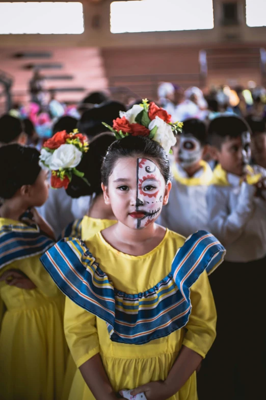 little girl in face paint standing by crowd