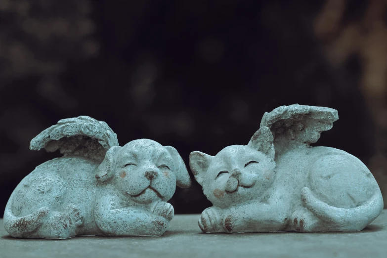 some small white statues with a cat and dog sitting side by side