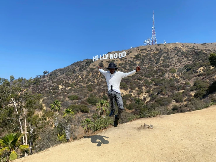 a person with his arms wide open on a mountain trail