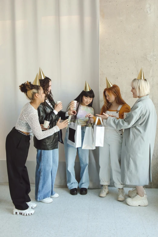 four women wearing party hats and making funny faces