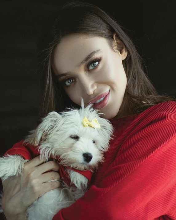 a girl holding a dog on her arms