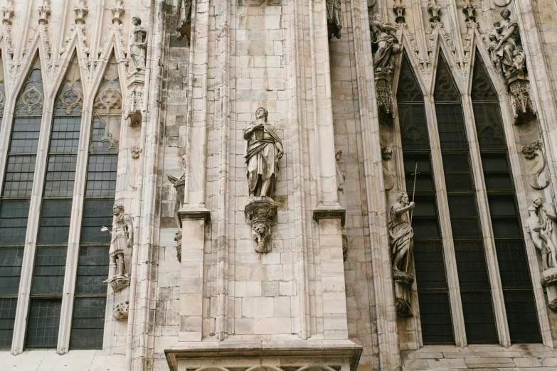 a gothic architecture with statues of a human figure on a building