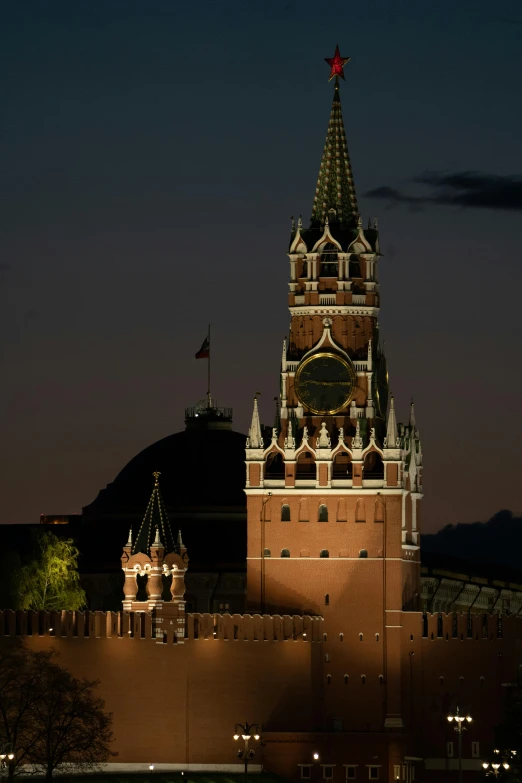 the top of a large building with a clock and several lights on it