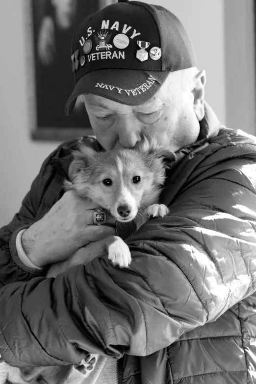 an older man holds a small dog in his lap