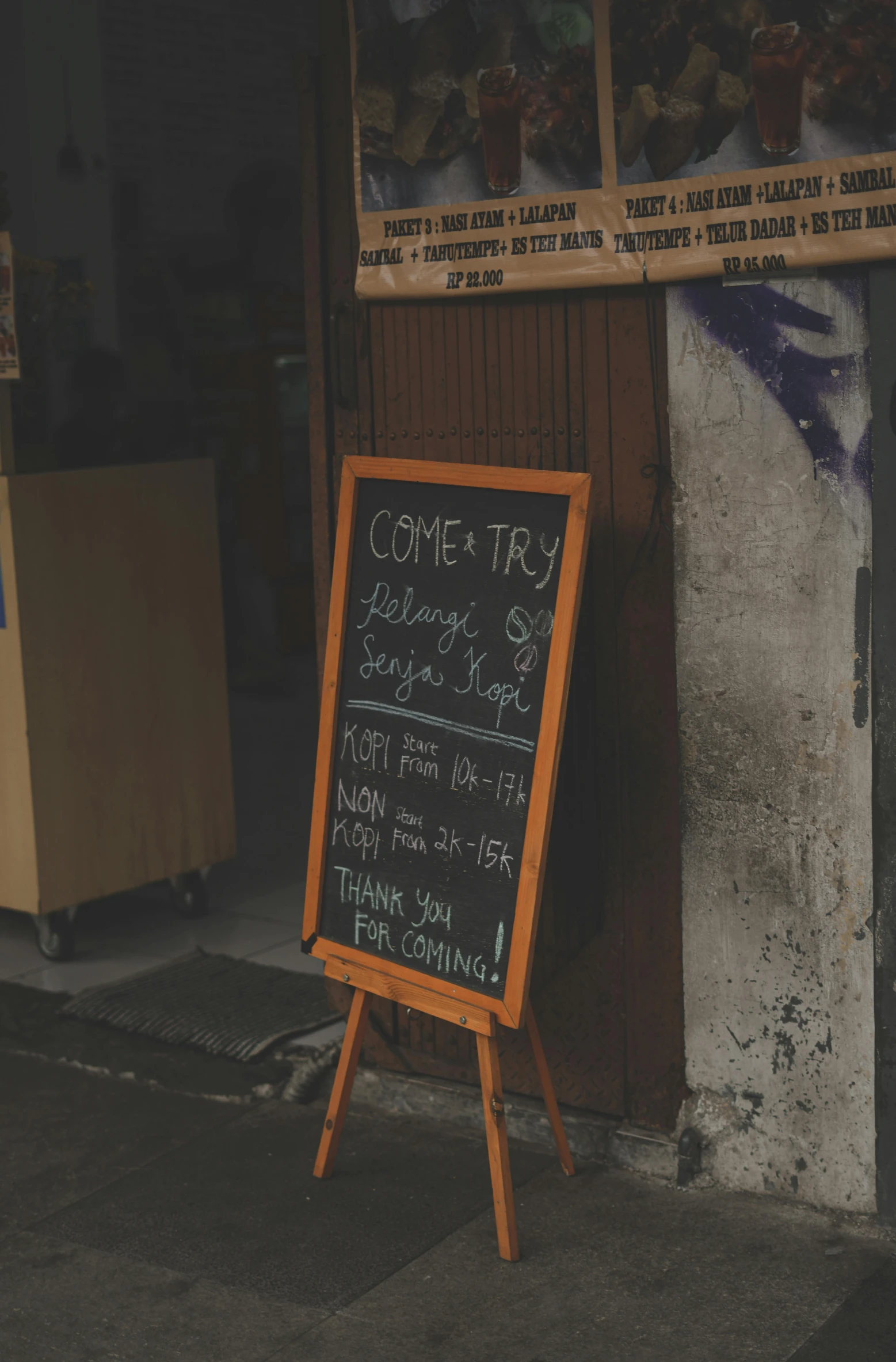 chalkboard advertising donuts and teas on the sidewalk