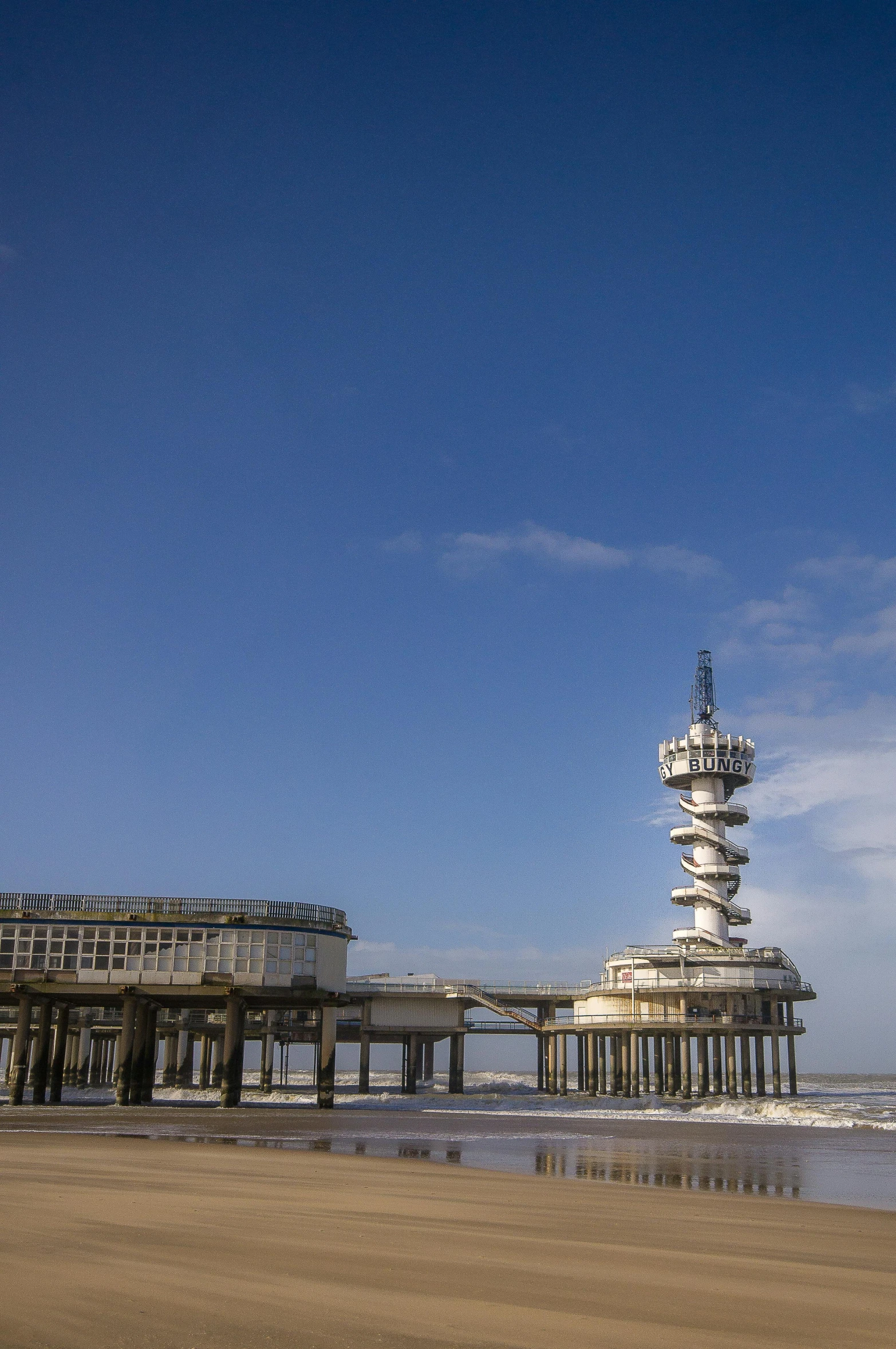 a tower sits high up in the distance on the beach