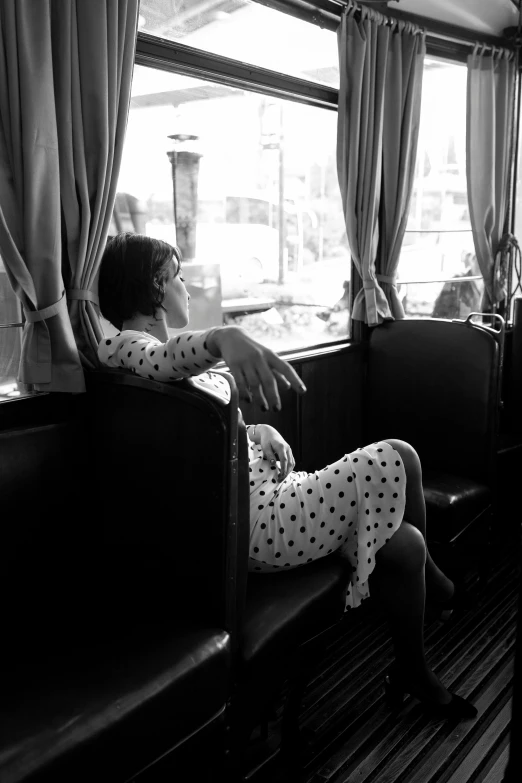 a person sitting on a train next to a window