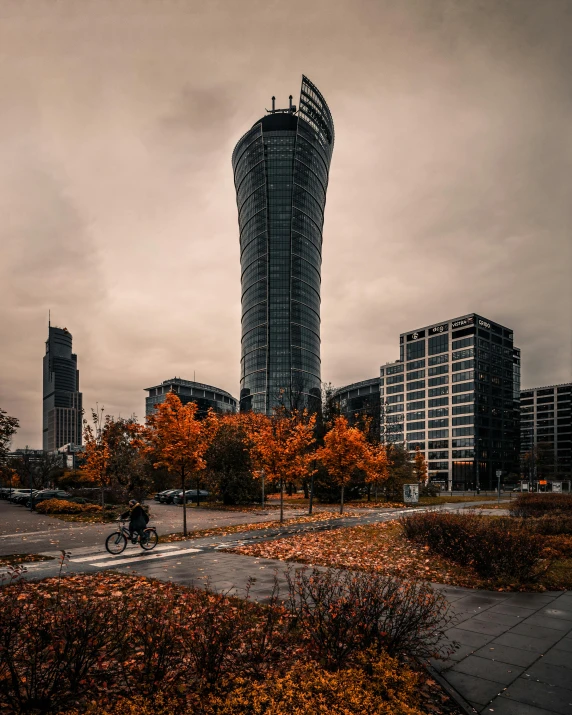 a person riding a bike next to a tall building