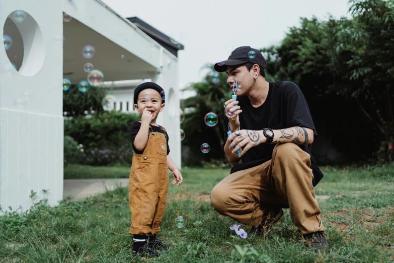 a father and son blowing bubbles together