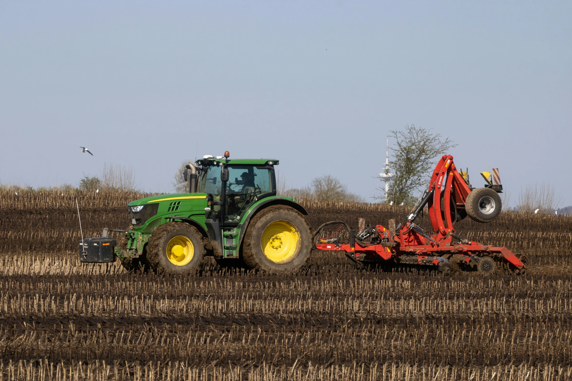 a tractor drives along in the middle of a field