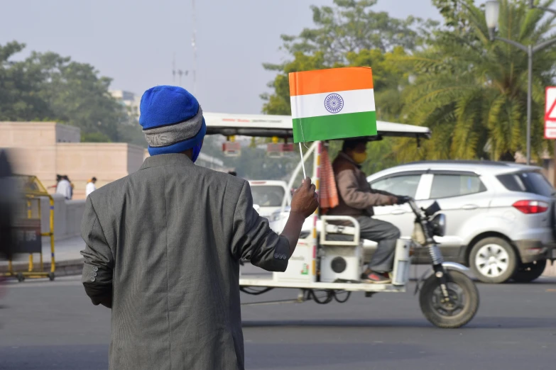 a man is holding an indian flag on his hand