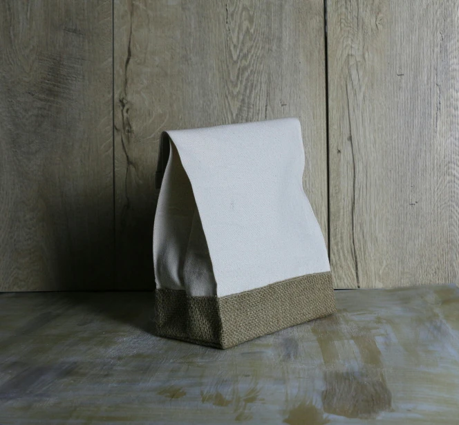 white and gray wrapped lunch bag on wood background