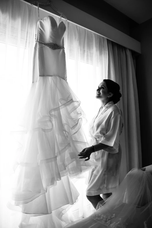 a woman is standing in front of two dresses