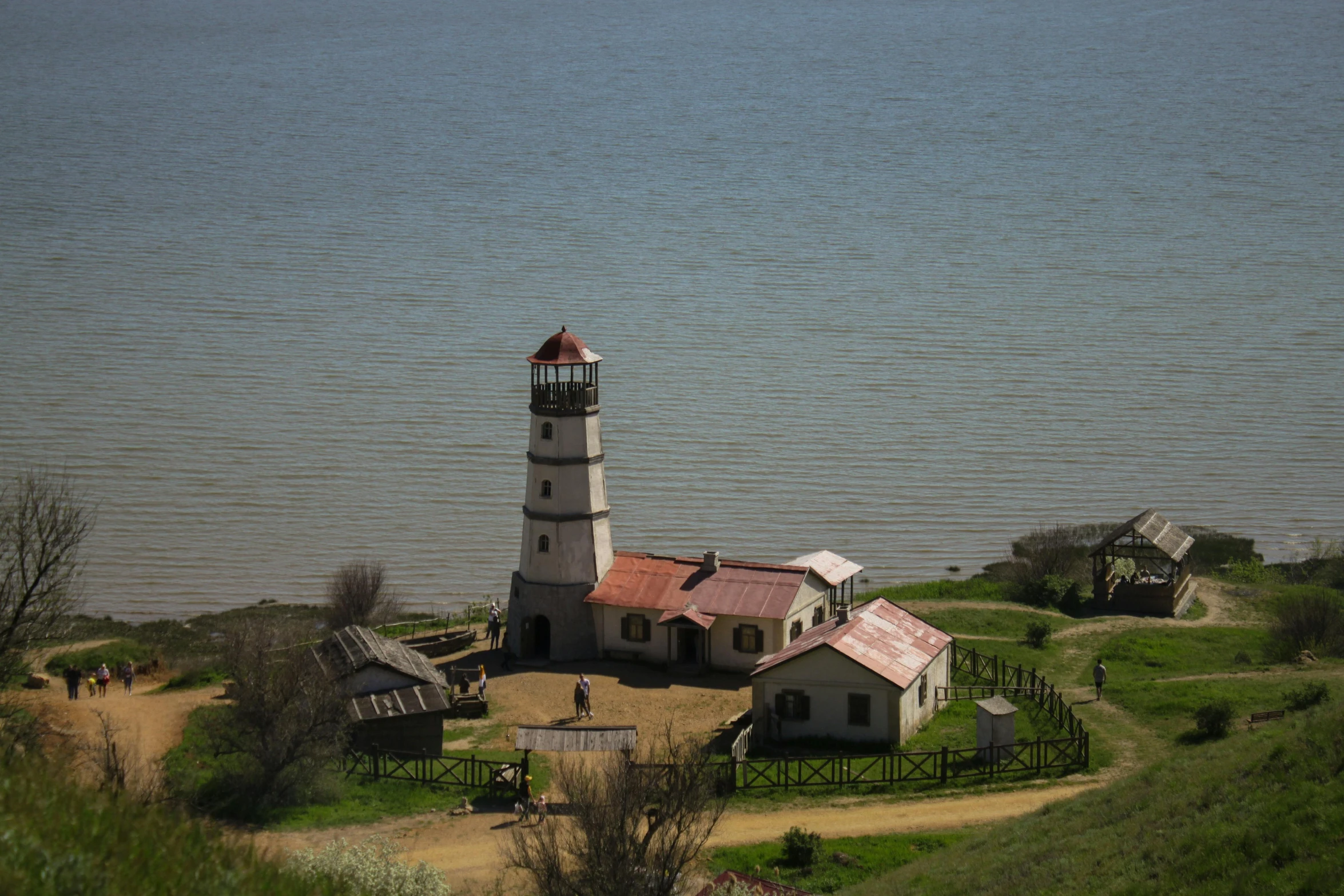 a white lighthouse next to a body of water